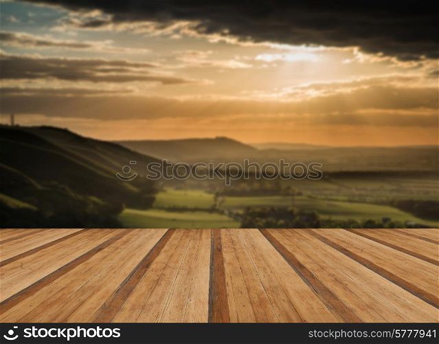 Beautiful Summer sunset over escarpment landscape with wooden planks floor
