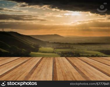 Beautiful Summer sunset over escarpment landscape with wooden planks floor