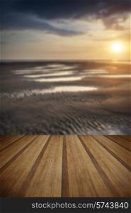 Beautiful Summer sunset over golden beach landscape with wooden planks floor