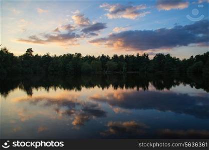 Beautiful Summer sunset reflected in still lake landscape