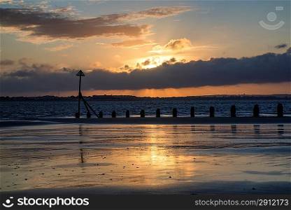 Beautiful Summer sunset sky reflected in wet low tide beach