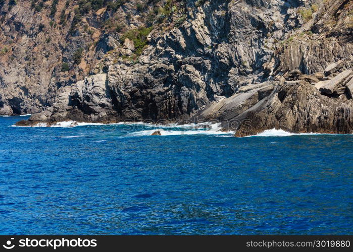 Beautiful summer Vernazza outskirts view from excursion ship. One of five famous villages of Cinque Terre National Park in Liguria, Italy, suspended between Ligurian sea and land on sheer cliffs.