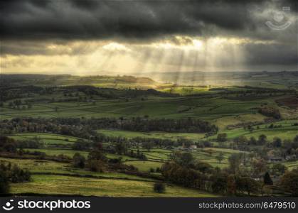 Beautiful sunbeams over Big Moor in the Peak District landscape . England, Derbyshire, Curbar Edge. Sunbeams over Big Moor in the Peak District in Autumn.. Stunning sunbeams over Big Moor in the Peak District landscape in Autumn