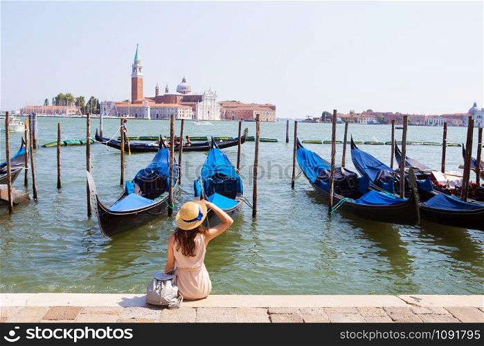 Beautiful sunny Venice-girl sitting on the pier, near the gondola.. Beautiful sunny Venice-girl sitting on the pier, near the gondola