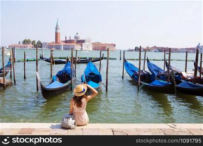 Beautiful sunny Venice-girl sitting on the pier, near the gondola.. Beautiful sunny Venice-girl sitting on the pier, near the gondola