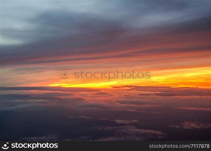 Beautiful sunrise above clouds from airplane perspective.