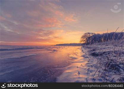Beautiful sunrise at a frozen sea shore in Scandinavia