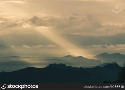 Beautiful sunrise in the mountains. Landscape with sun shining through orange clouds in Myanmar