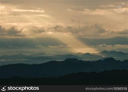 Beautiful sunrise in the mountains. Landscape with sun shining through orange clouds in Myanmar