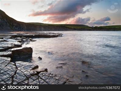 Beautiful sunrise landscape image at Kimmeridge Bay on Jurassic Coast, Dorset, England