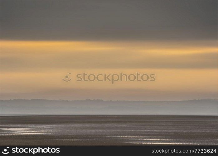 Beautiful sunrise landscape image of Talacre beach at surnise with dramatic sky and clouds 