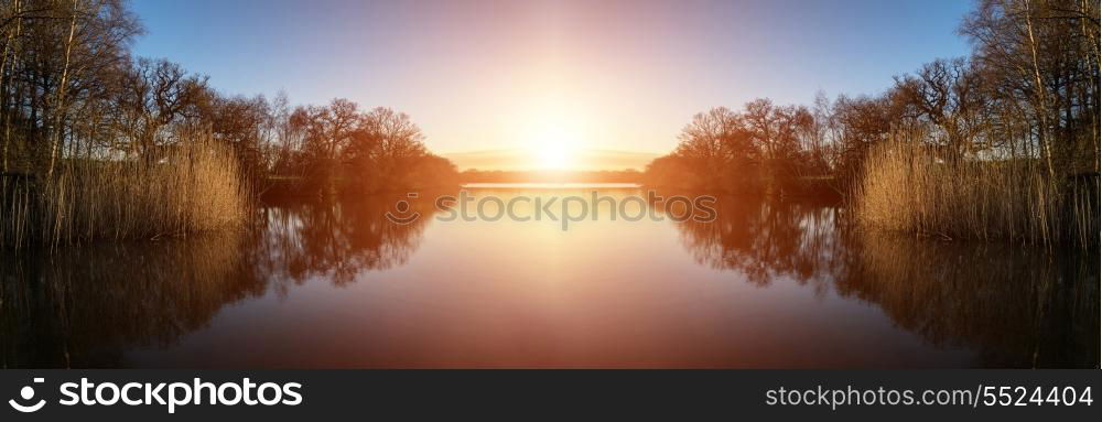 Beautiful sunrise landscape over lake with reflections and jetty