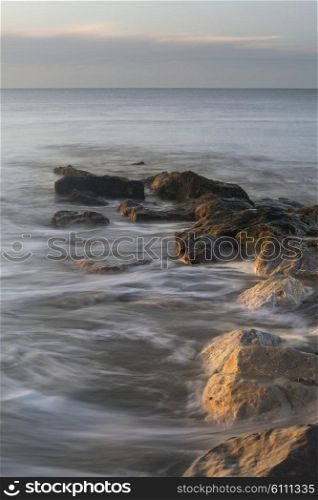 Beautiful sunrise landscape over rocks in sea