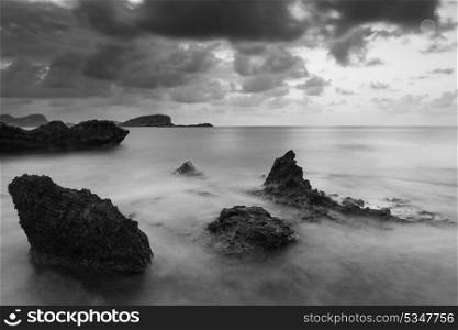 Beautiful sunrise landscape seascape over rocky coastline in Mediterranean Sea in black and white