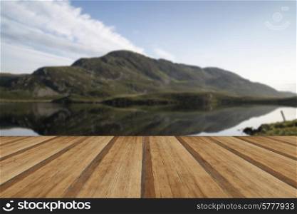 Beautiful sunrise mountain landscape reflected in calm lake. Beautiful sunrise reflected in calm Lakes landscape with wooden planks floor