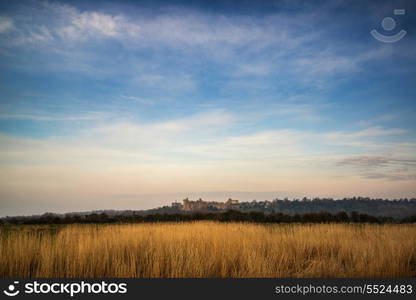 Beautiful sunrise over medieval castle in distant landscape