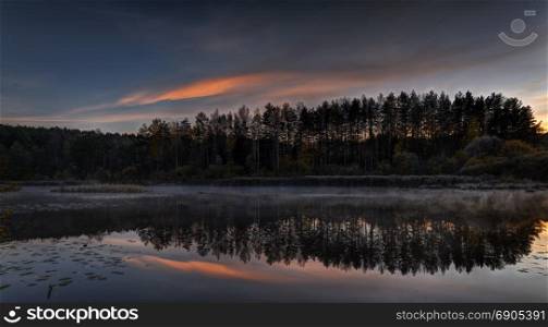 Beautiful sunrise over quiet lake. October morning near Vilnius, Lithuania