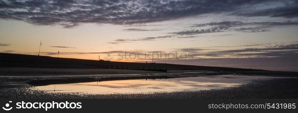 Beautiful sunrise panorama landscape reflected in pools on beach