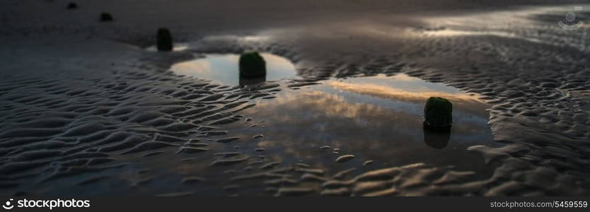 Beautiful sunrise panorama landscape reflected in pools on beach