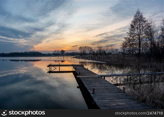 Beautiful sunset and clouds over the lake with pier, Stankow, Poland