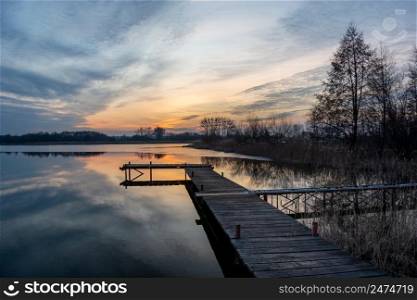 Beautiful sunset and clouds over the lake with pier, Stankow, Poland