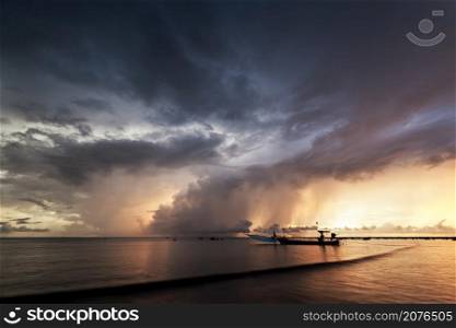 beautiful sunset and rain storm with Opossum shrimp boats moored at the port on the Pakarang beach Phang Nga, Thailand
