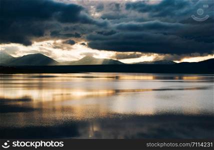 Beautiful Sunset And Reflections with mountains and dark clouds on Lake, Tsalka Georgia