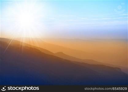 Beautiful sunset at the mountains. Beautiful sunset at the mountains. Colorful landscape with sun rays and blue sky