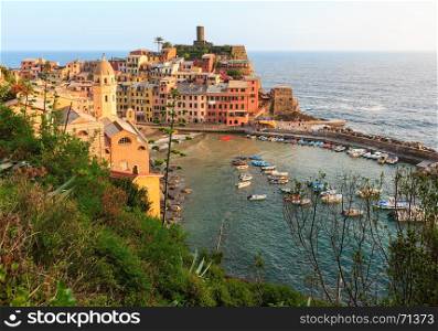Beautiful sunset in summer Vernazza - one of five famous villages of Cinque Terre National Park in Liguria, Italy, suspended between Ligurian sea and land on sheer cliffs. People and signs unrecognizable.