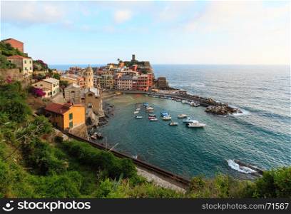 Beautiful sunset in summer Vernazza - one of five famous villages of Cinque Terre National Park in Liguria, Italy, suspended between Ligurian sea and land on sheer cliffs. People unrecognizable.