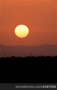 Beautiful sunset in summer with a round sun and orange sky