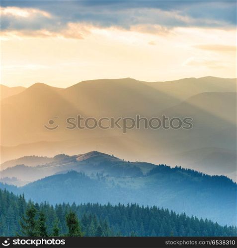 Beautiful sunset in the mountains. Landscape with sun shining through orange clouds. Beautiful sunset in the mountains