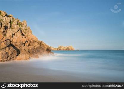 Beautiful sunset landscape image of Porthcurno beach on South Cornwall coast in England