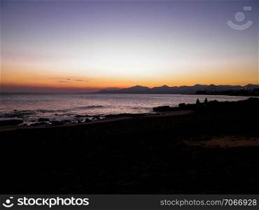 Beautiful sunset on beach in Puerto del Carmen, Lanzarote, Canary Islands. Travel and nature concept.. Beautiful sunset on beach in Puerto del Carmen, Lanzarote, Canary Islands.