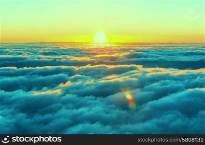 Beautiful sunset on the hill above clouds