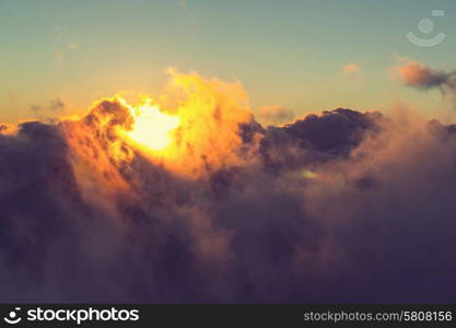 Beautiful sunset on the hill above clouds