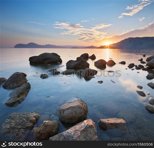 Beautiful sunset on the sea shore. Nature seascape composition.