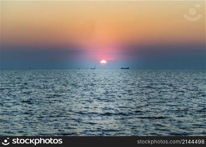 Beautiful sunset over a calm sea with a blue and orange glowing sky. Space for text, Selective focus.