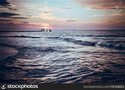 Beautiful sunset over sea horizon. Soft colors, mood and magic, subtle light. Small clouds in the sky. Concept of romantic summertime and vacation
