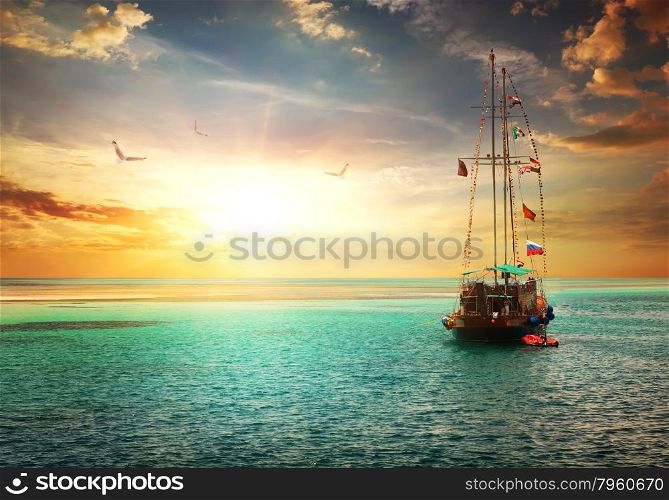 Beautiful sunset over yacht in the sea
