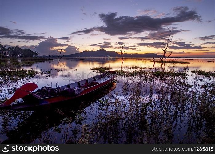 beautiful sunset sky and wood boat floating in bangpra water reservoir lake chonburi eatern of thailand