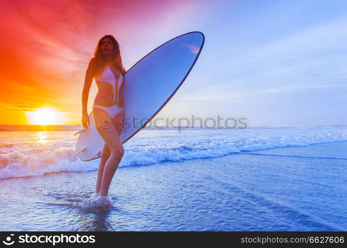 Beautiful surfer woman on the beach at sunset. Surfer woman on beach at sunset