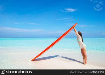 Beautiful surfer woman ready to surfing in turquoise sea with red paddle board at exotic vacation. Beautiful surfer woman ready to surfing in turquoise sea, on stand up paddle board at exotic vacation
