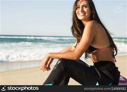 Beautiful surfist sitting over her surfboard