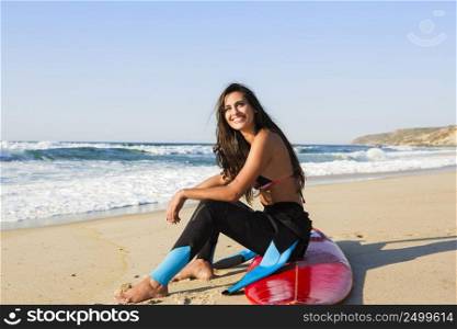 Beautiful surfist sitting over her surfboard