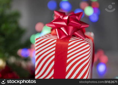 beautiful surprise gift box with a red bow on the background of bokeh garlands for the holiday Valentine’s Day and New Year