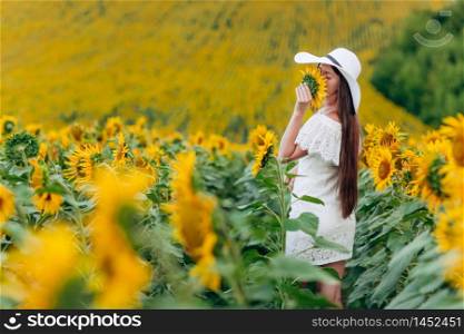 beautiful sweet young woman in a white dress and hat in a field of sunflowers. girl is holding sunflower in her hand. summer holiday. beautiful sweet young woman in a white dress and hat in a field of sunflowers. girl is holding sunflower in her hand. summer holiday,