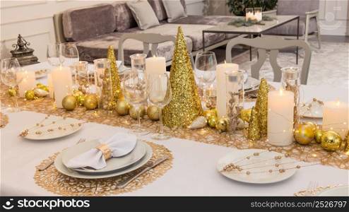 Beautiful table setting with Christmas decorations. Gold colors. christmas table decoration