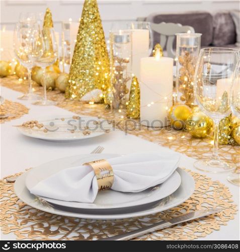 Beautiful table setting with Christmas decorations. Gold colors. christmas table decoration