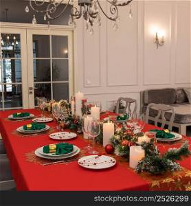 Beautiful table setting with Christmas decorations. Red colors. Interior of the room. christmas table decoration